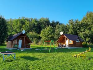 a log cabin with a playground and a house at Шафран in Krasnaya Slobodka