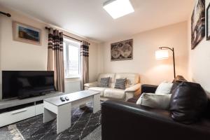 a living room with a couch and a tv at Cheerful 4 Bedroom townhouse with free parking in Exhall