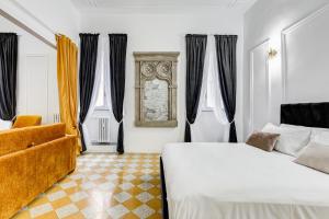 a bedroom with a bed and a chair and windows at NEW!! SPAGNA Suite - Your Italian Holidays in Rome