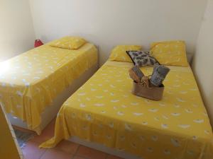 - 2 lits dans une chambre avec des draps jaunes dans l'établissement Les Tuiles Rouges, à Fort-de-France