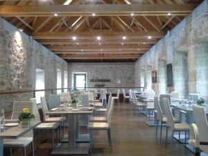 a dining room with tables and white chairs at Casa de la Moneda in Segovia