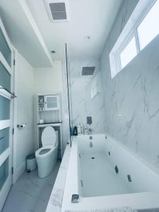baño blanco con bañera y aseo en Gorgeous 3 bedroom lake house Suite!, en Shawnigan Lake