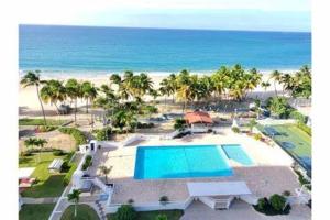 een luchtzicht op een resort met een zwembad en het strand bij Beachfront Tropical Tantra Apartment in San Juan