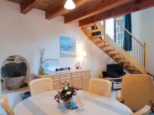 uma sala de jantar com uma mesa e cadeiras e uma escadaria em Cottage Chapel, Briec em Briec