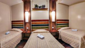 Habitación con 3 camas en una habitación en Los Ríos de Baños en Baños
