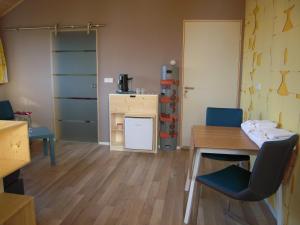 a room with a desk and a table and chairs at B&B ZomersBuiten in Oude Pekela +17 photos