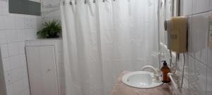 a bathroom with a white shower curtain and a sink at HOSPEDAJE DEL PASEO in La Rioja