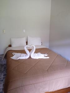 a bed with two white towels on it at Lia B&B Lucmabamba in Sahuayacu