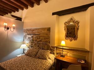 een slaapkamer met een bed en een spiegel aan de muur bij Apart. San Pedro II - junto a catedral in Toledo