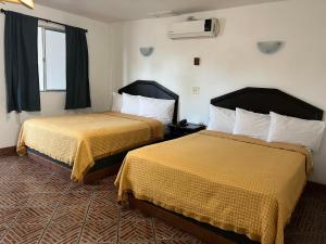 a hotel room with two beds and a window at Hotel La Quinta Bonita in Ensenada +31 photos