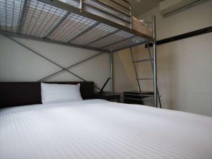 a bedroom with a white bed and a bunk bed at Green Rich Hotel Osaka Airport in Ikeda