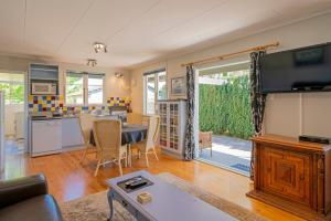 a living room with a table and a kitchen at Rooftops Accommodation in Whitianga