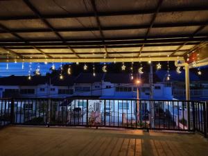 a room with a balcony with lights and a fence at Sweethome Homestay Sandakan in Sandakan