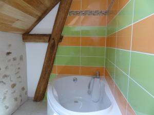 y baño con bañera y azulejos de colores. en Gîte Blomard, 4 pièces, 6 personnes - FR-1-489-40, en Blomard