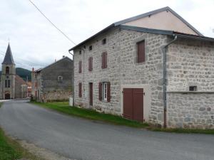 un antiguo edificio de piedra al lado de una carretera en Gîte La Guillermie, 5 pièces, 14 personnes - FR-1-489-188 en La Guillermie