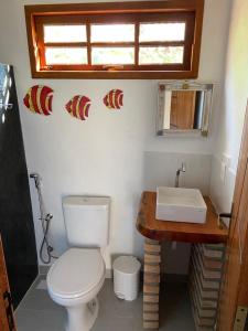 Łazienka z białą toaletą i umywalką w obiekcie CHALÉS MELGAÇO w mieście Cumuruxatiba