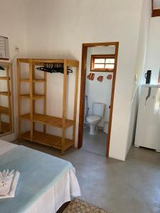 CHALÉS MELGAÇO في كوموروكساتيبا: غرفة بحمام مع مرحاض وثلاجة