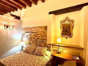 1 dormitorio con cama, escritorio y espejo en Apart. San Pedro II - junto a catedral, en Toledo
