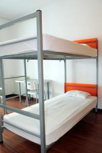 a bunk bed in a room with a table at HI Porto - Pousada de Juventude in Porto