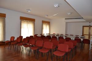 Una habitación vacía con sillas rojas y una mesa. en HI Porto - Pousada de Juventude, en Oporto