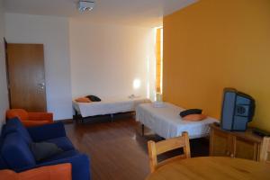 Habitación con 2 camas, TV y sofá. en HI Porto - Pousada de Juventude, en Oporto
