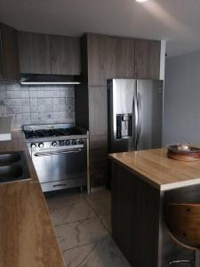 a kitchen with a stainless steel refrigerator and a counter at Apartamento cerca de Centro CitiBanamex in Mexico City