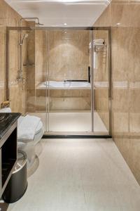 ein Badezimmer mit einer Dusche, einem WC und einer Badewanne in der Unterkunft The Almin Hotel in Hạ Long