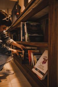 a person is looking at books on a shelf at Lagoa Nômade Hostel in Florianópolis