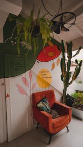 una silla en una habitación con una pared con un cactus en Lagoa Nômade Hostel en Florianópolis