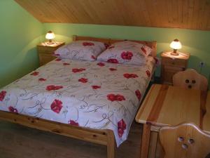 a bedroom with a bed with red flowers on it at Pokoje gościnne u Krysi in Mizerna