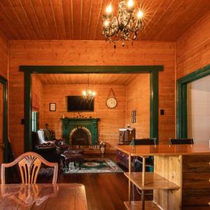 a living room with a fireplace and a chandelier at Kerrellie Cottages 2, 4 & 8 Reid Street in Strahan