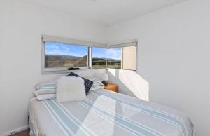 a small bedroom with a bed and a window at Apollo Blue Ocean View Unit 1-A Free WIFI in Apollo Bay