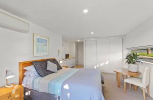 a bedroom with a bed and a table and a chair at Apollo Blue Oceanview Unit 1- B Free WIFI in Apollo Bay