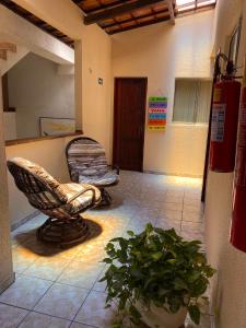 a living room with a chair and a plant at Pousada do Suiço in Fortaleza