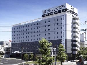 a building with a sign on the top of it at Green Rich Hotel Osaka Airport in Ikeda