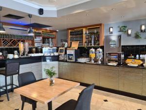 um restaurante com uma mesa de madeira e um bar em Great Southern Hotel Perth em Perth