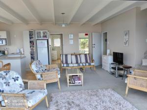 a living room filled with furniture and a tv at Hosts on the Coast Paradise on Pipi in Whangamata