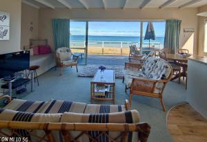 a living room with a view of the ocean at Hosts on the Coast Paradise on Pipi in Whangamata