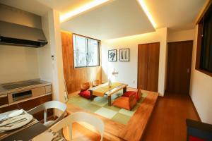 a kitchen and living room with a table and chairs at PrimeRoom別府 TATAMIsuite in Beppu