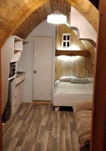 1 dormitorio con 1 cama en una habitación con techos de madera en Cabañas Peñaflor Glamping, en Talagante