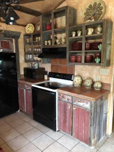eine Küche mit einem Herd und einem schwarzen Kühlschrank in der Unterkunft Antler Mountain House in Tarpley