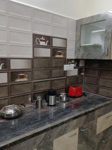 a kitchen with a counter with pots and pans on it at Doctor's Homestay in Tiruvannāmalai