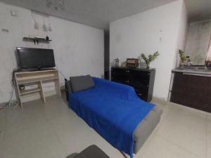 a bedroom with a bed and a desk and a television at Estancia 311 Backpackers in Cajamarca