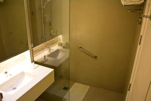 a bathroom with a sink and a mirror at Harolds Evotel Cebu in Cebu City