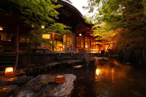 un bâtiment avec une rivière devant lui dans l'établissement Yorozuya, à Yamanouchi