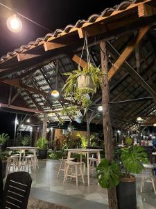 a restaurant with tables and chairs and potted plants at Nipoh Beach Cottage in Kijal