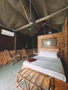 a bedroom with a bed and a brick wall at Nipoh Beach Cottage in Kijal