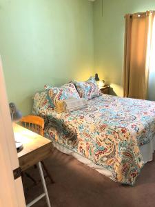 1 dormitorio con cama y mesa de madera en Country haven room with desk near wineries, en Hemet