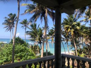 a view of the beach from the balcony of a resort at SunRay Rest - Beach View Homestay in Mirissa