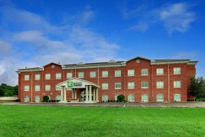 Holiday Inn Express Campbellsville, an IHG Hotel في Campbellsville: مبنى من الطوب الأحمر مع حديقة أمامه